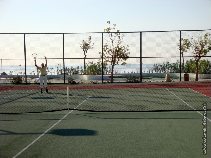 playing tennis with the beach starting just next to the court
